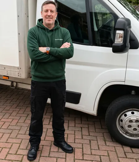 Darren Thomas, co-founder of Green4Logistics, standing beside a removals van in Stoke-on-Trent